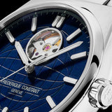 Close-up of a Frederique Constant wristwatch with a deep blue sunburst dial, silver-tone case, and visible tourbillon mechanism.