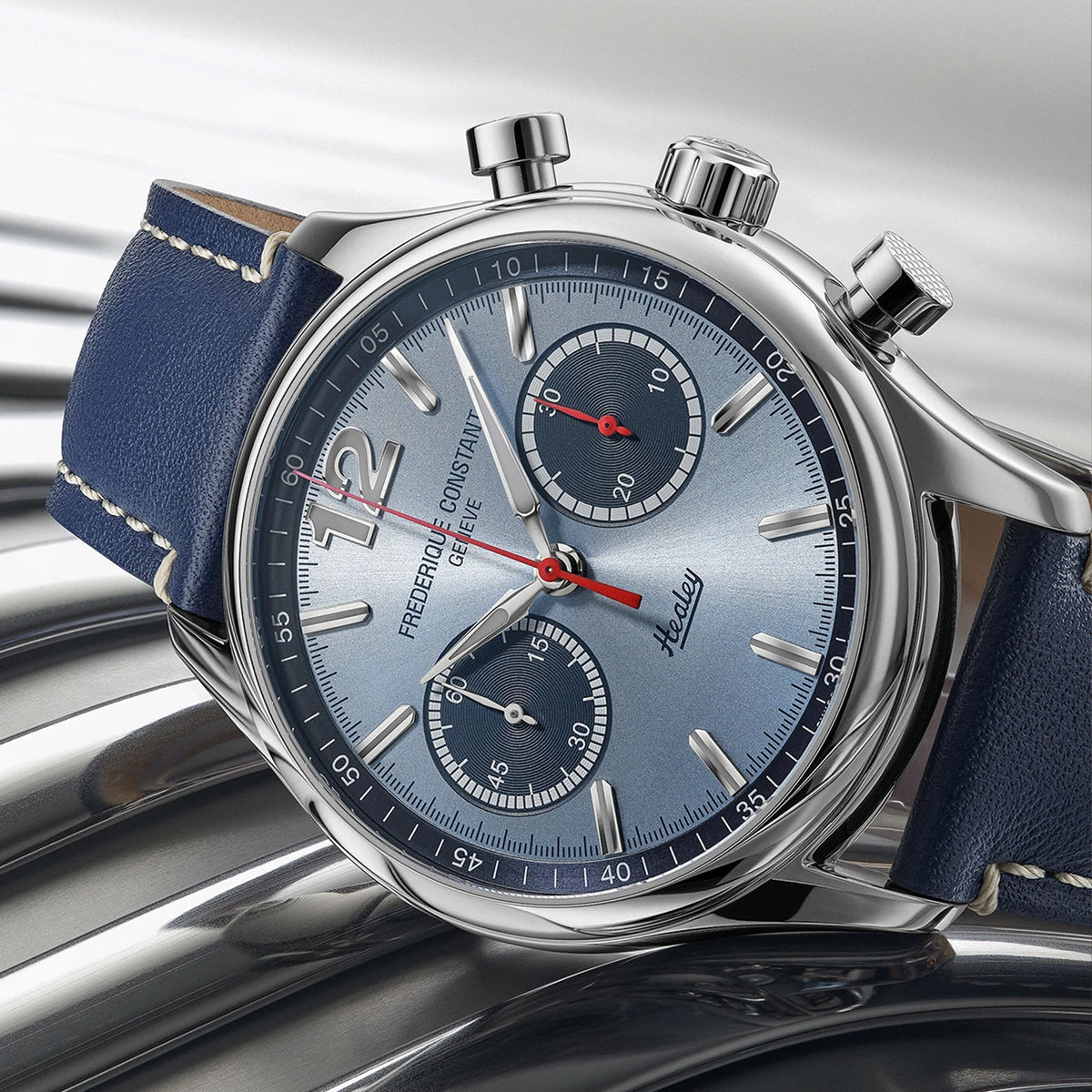 Frederique Constant Classic Automatic Chronograph Men's 42mm Watch FC-397HLBN5B6 styled in a lifestyle setting, reflecting its vintage motorsport-inspired design suited to casual and smart-casual wear. The light blue dial and navy leather strap suit a classic, heritage-driven look.