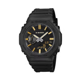 The Casio G-Shock Analogue Digital Men's Watch GA2100LXB-1A9 features a deep matte black anti-reflective textured dial with slim extended hands and gold vapour-deposited hour markers, set within a 48.5mm Carbon Core Guard black octagonal resin case.