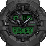 Casio G-Shock GA100BEG-1A front view — all-black round resin case with electro green LCD accents, analogue-digital three-dial layout. 55mm x 51.2mm x 16.9mm, 70 grams, shock resistant, magnetic resistant, 200M water resistant.