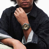 Worn on the wrist, the Casio G-Shock GA700CMG-3A demonstrates the large, commanding 57.5mm presence of the GA-700 with the bold green camo and gold vapour deposition contrast — a distinctive street fashion statement.