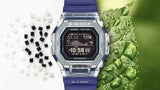 Casio G-SHOCK G-LIDE GBX100S-2D digital watch front view, featuring a square-case design with a dual-material bezel of stainless steel and translucent purple resin, high-definition MIP LCD display, and silver-tone accents.