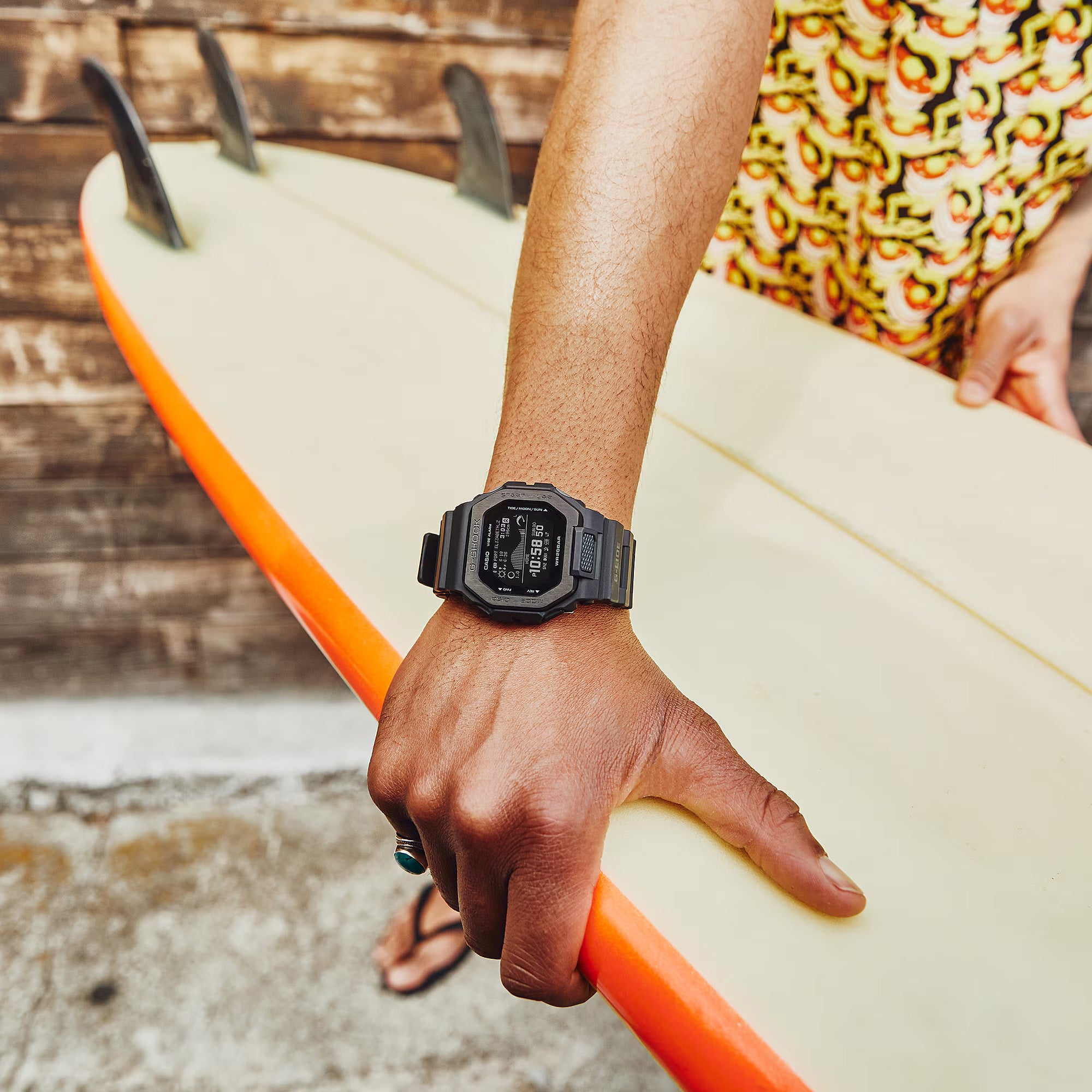 Casio G-LIDE GBX100NS-1D digital surf watch with black resin band, MIP LCD display, Bluetooth connectivity, and tide graph functions on hand