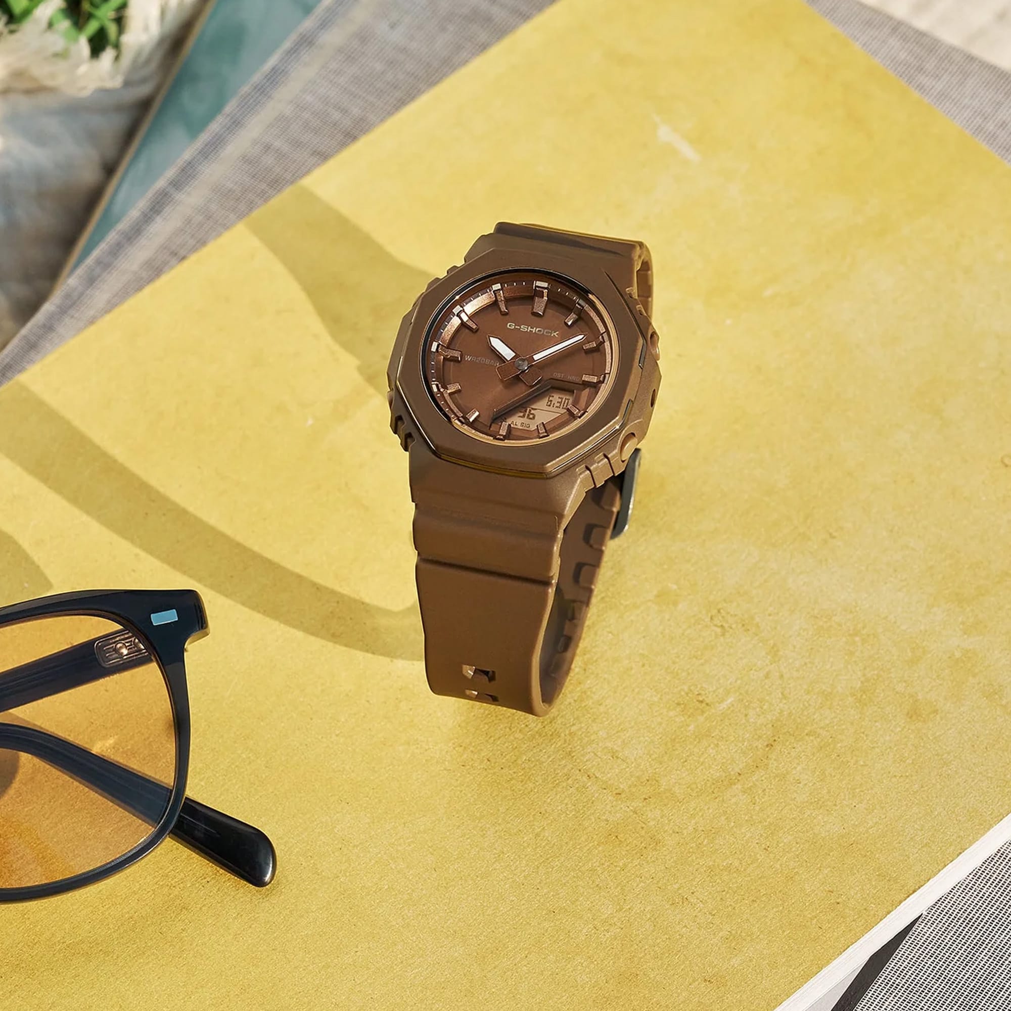 Lifestyle shot of the Casio G-SHOCK Analogue Digital Women's Watch GMA-P2110B-5A, 40.5mm case, styled in an everyday active setting. The compact all-brown design is shown in a natural, real-world context.