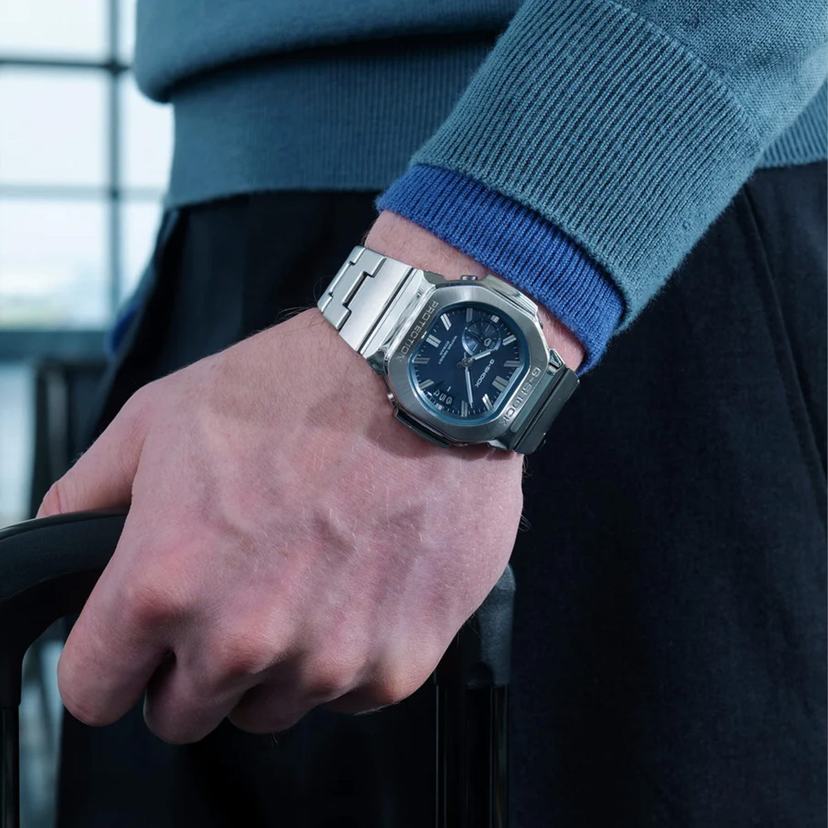 The Casio G-SHOCK 2500 Series Quartz Men’s Watch GMC2500D-1A2, 46.7mm case, worn on the wrist. The stainless steel bracelet and blue dial show the scale and fit.