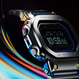 Casio G-Shock GMWBZ5000RC-1D front view showcasing the iconic square full-metal case with interlocking bezel-to-centre-case connection, gradient rainbow ion-plated centre case shifting brilliantly with the light, four gold IP front screws, rainbow vapour deposition glass border, and high-definition MIP LCD — the AI-generative designed GMW-BZ5000 in its most vivid colourway.