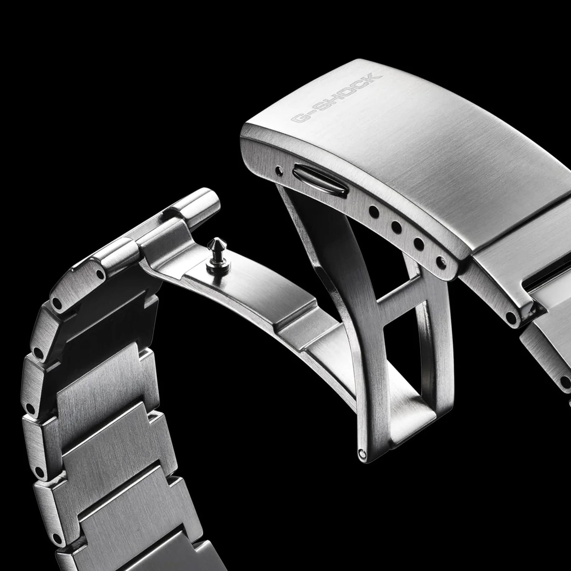 Metallic watch strap with 'G-Shock' branding on a black background