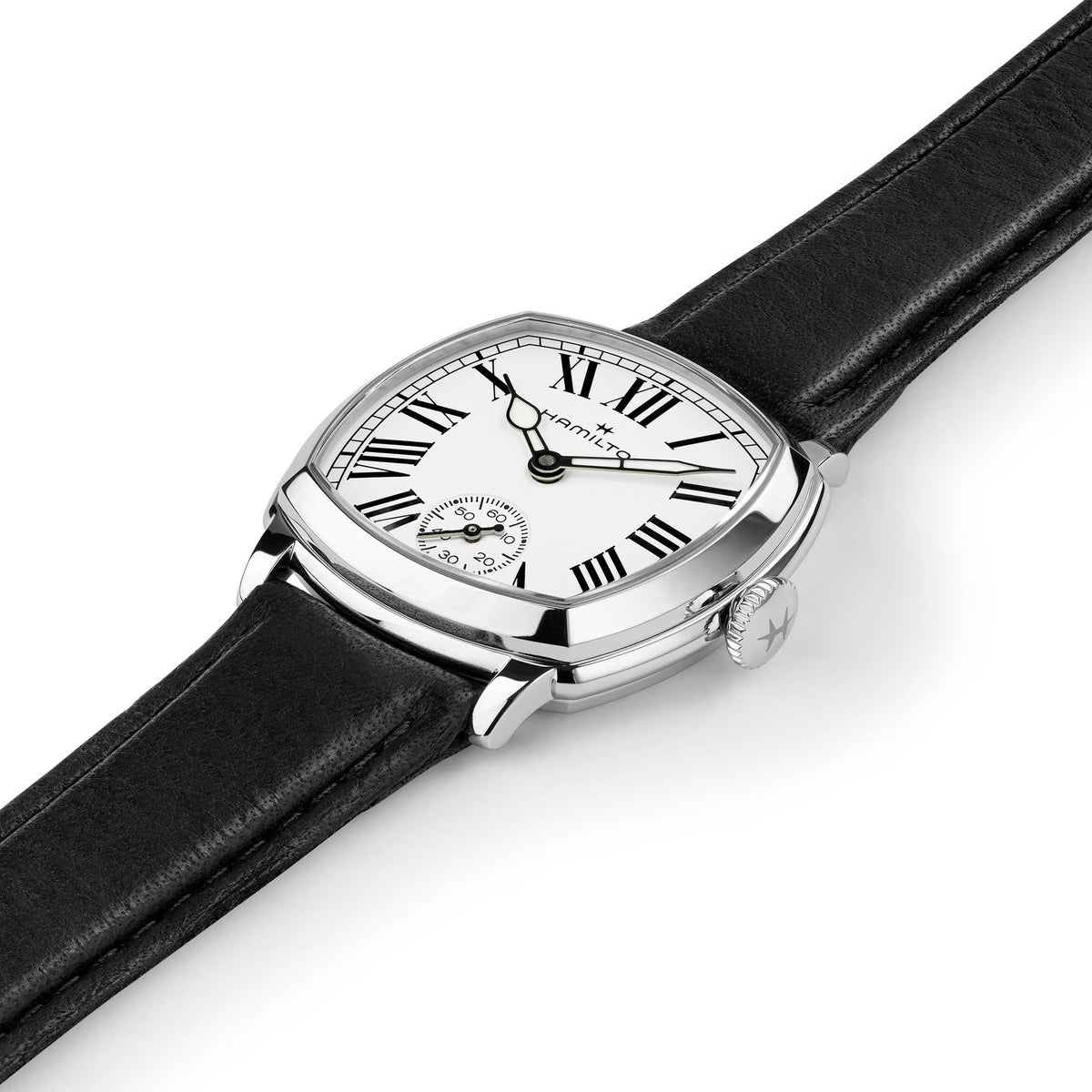Hamilton American Classic Cushion Mechanical Women’s 30mm Watch H36109710 is captured at a 3/4 angle, showing the white dial, steel case and black leather strap together. The angle highlights the soft cushion shape of the case.