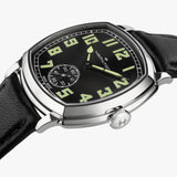Hamilton American Classic Cushion Mechanical Unisex 34mm Watch H36129730 is shown from the side, displaying the slim cushion-shaped steel case and crown. The black leather strap extends from the lugs beneath the sapphire crystal.