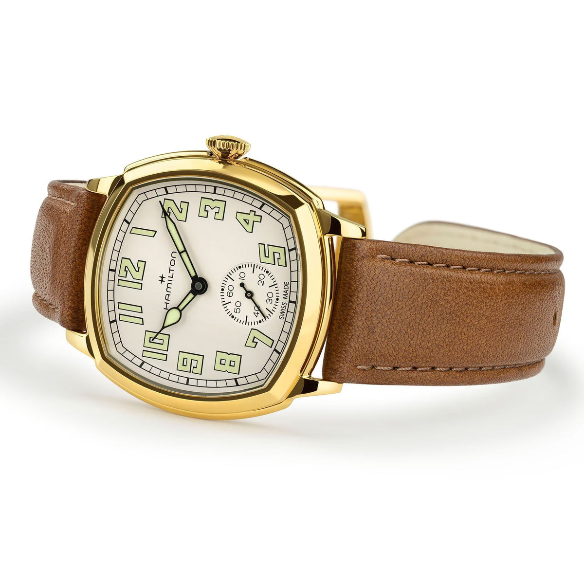 Hamilton American Classic Cushion Mechanical Unisex 34mm Watch H36139520 is captured at a 3/4 angle, showing the beige dial, yellow gold PVD case and brown leather strap together. The angle highlights the soft cushion shape of the case.