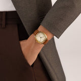 Hamilton American Classic Cushion Mechanical Unisex 34mm Watch H36139520 is worn on the wrist with its brown leather strap fastened. The square case and beige dial suit a classic dress watch look.