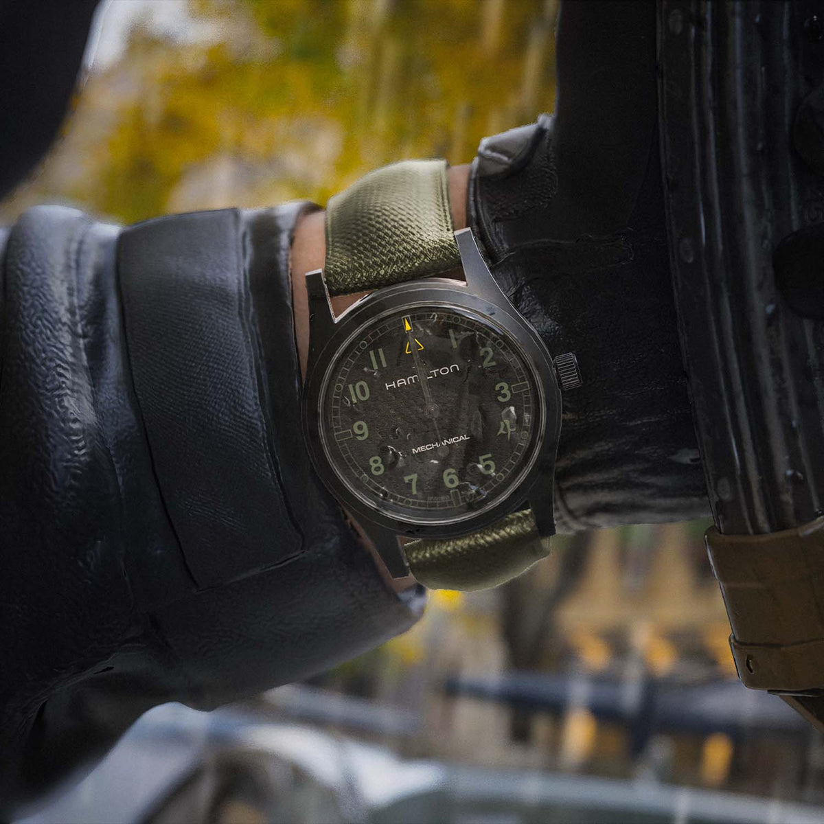 Hamilton x Call of Duty Khaki Field Mechanical Men’s 38mm Watch H69469930 is worn on the wrist with its khaki green fabric strap fastened. The black case and dial suit a rugged military-inspired field watch look.