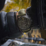 Hamilton x Call of Duty Khaki Field Mechanical Men’s 38mm Watch H69469930 is worn on the wrist with its khaki green fabric strap fastened. The black case and dial suit a rugged military-inspired field watch look.