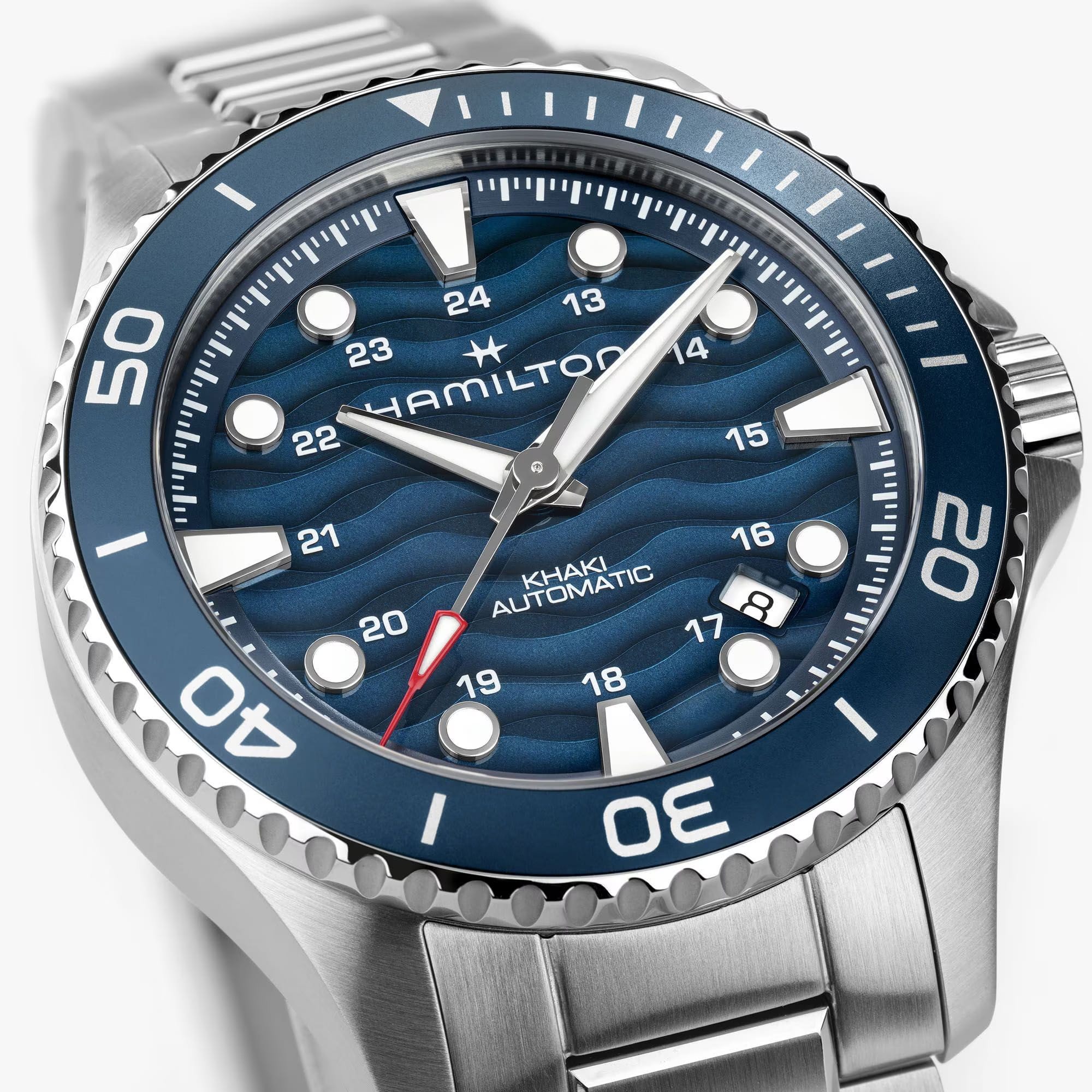 Hamilton Khaki Navy Scuba Auto 40mm Watch H82425140 is shown at a 3/4 angle, highlighting the sapphire crystal, wave-textured blue dial, and unidirectional bezel together. The angle showcases the watch's dynamic, diving-inspired design.