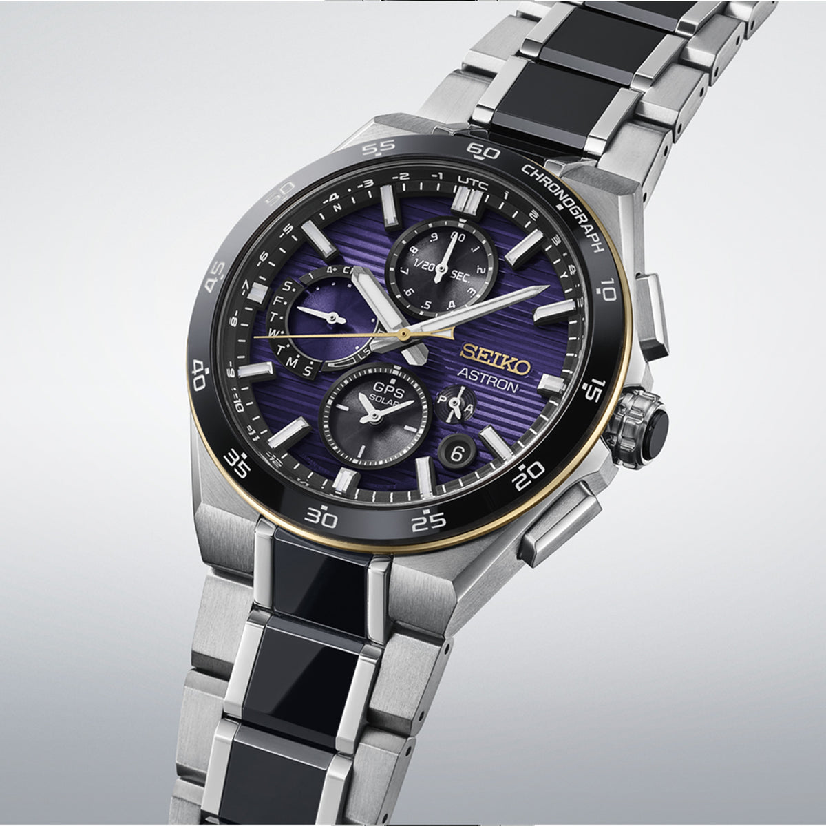 A Seiko Autumn chronograph watch with a silver stainless steel link bracelet, black inlay segments, and a purple sunburst dial with black subdials and a gold-tone bezel.