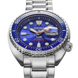 The Seiko Prospex P.A.D.I HBB002K displays its blue dial with a globe motif and red accents, framed by a blue ceramic unidirectional bezel. LumiBrite-treated hands and markers sit alongside a day/date window on the 45mm stainless steel case.
