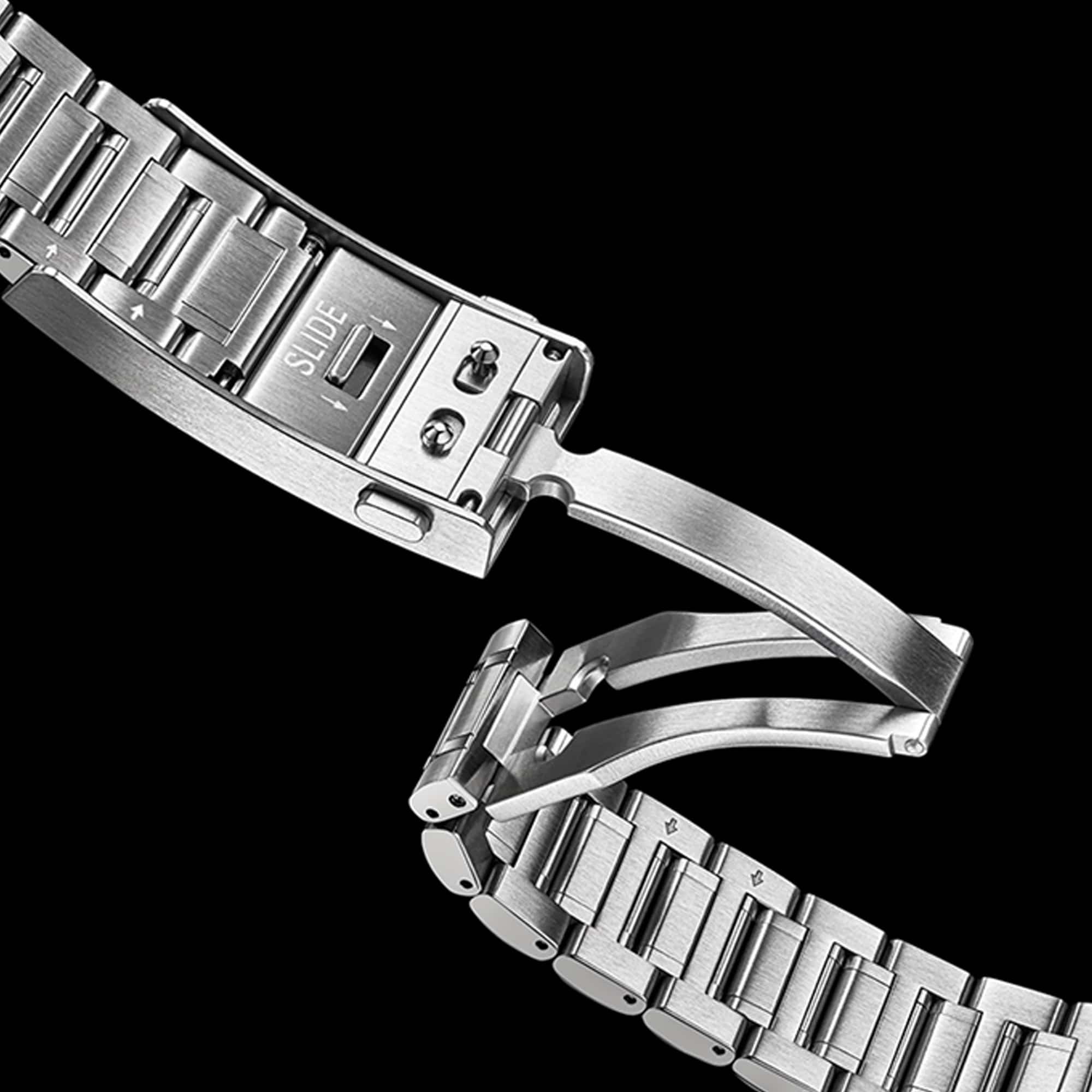 Close-up of a stainless steel watch band clasp and links on a solid black background.