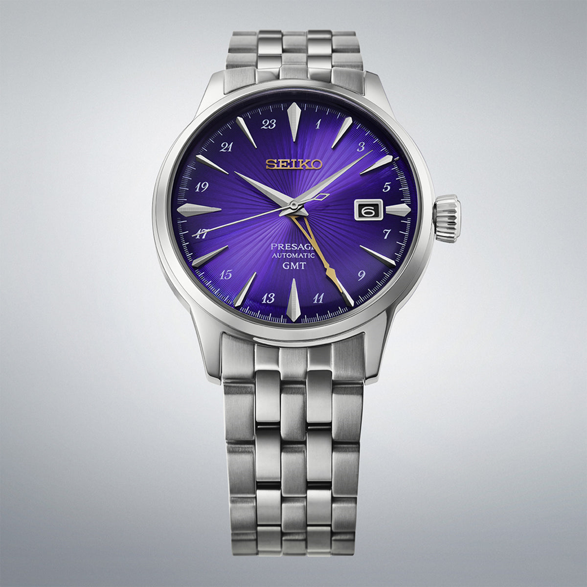 From this angle, the Seiko Presage Cocktail Time Automatic GMT Men's 40.50mm Watch HCB006J shows the purple dial's radial texture and gold accents together with the stainless steel case and bracelet.