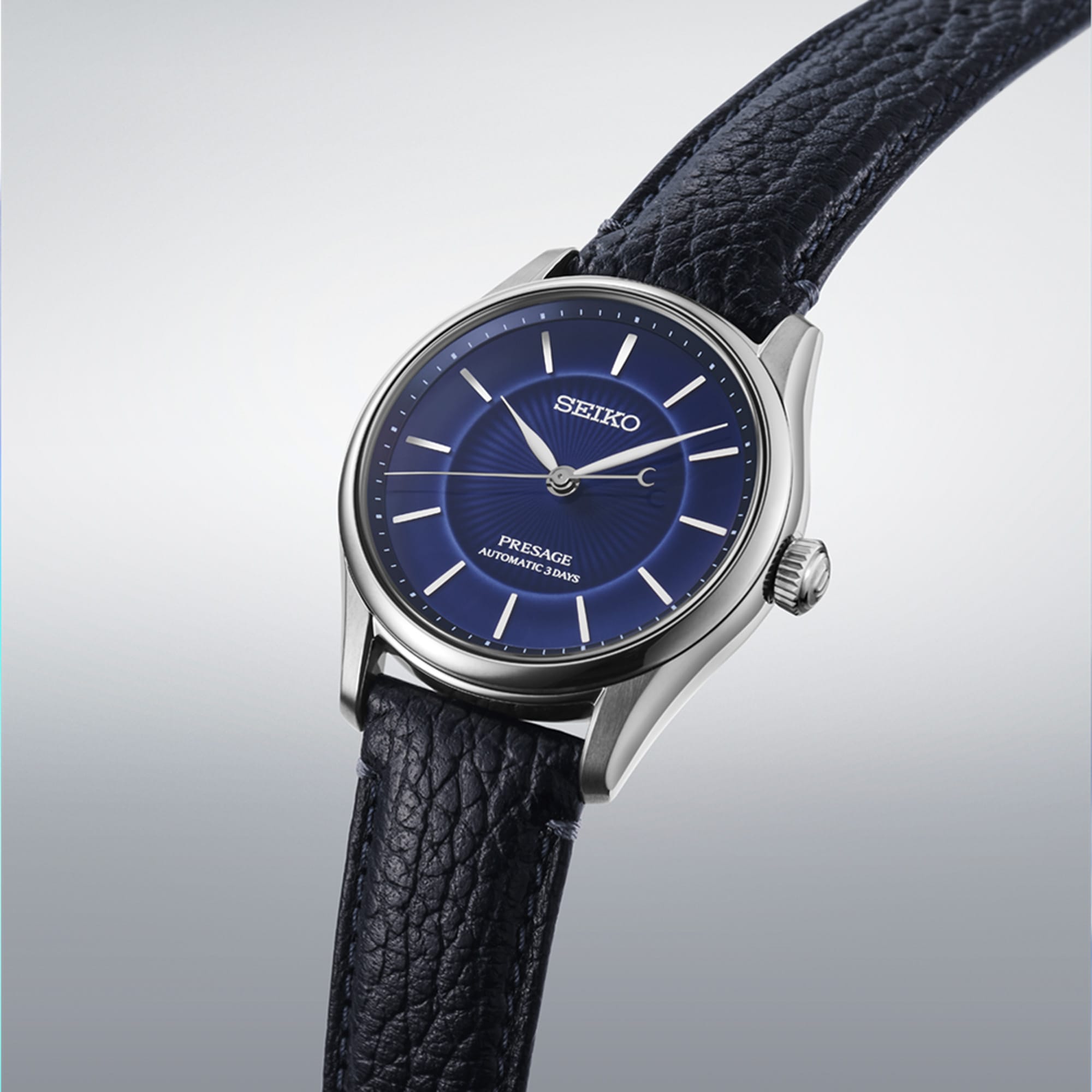 From this angle, the Seiko Presage 145th Anniversary Automatic 39.60mm Men's Watch HCC007J shows the cobalt blue porcelain dial's tonal depth and radiating pattern together with the leather strap and stainless steel case.