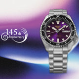 A Seiko 5 Sports SKX Series Automatic Men's 42.50mm Watch HDB003K with a purple dial and black bezel, shown on a purple and blue gradient background with a '145th Anniversary' logo on the left.