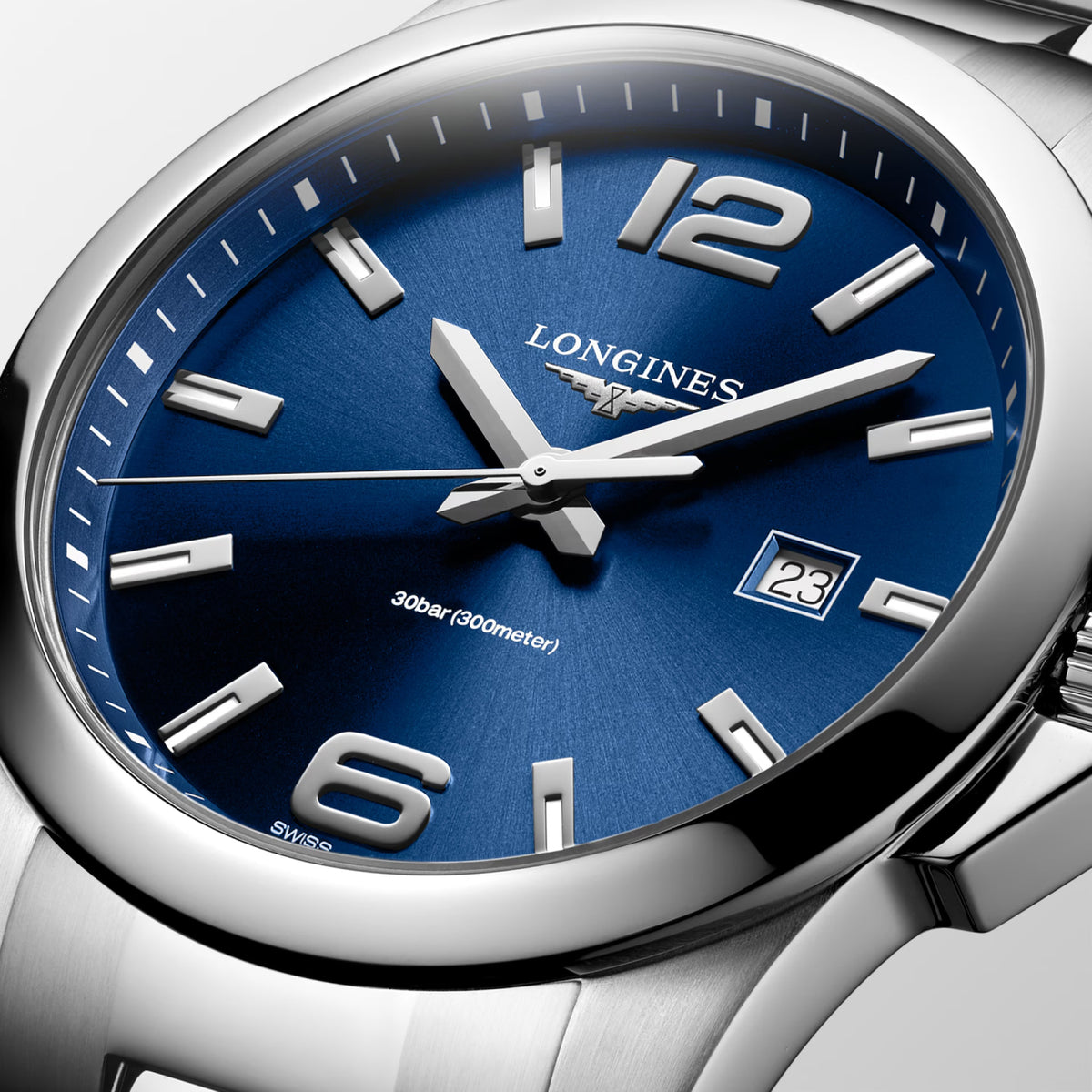Close-up of the sunray blue dial on the Longines Conquest Men's 43mm Stainless Steel Quartz Watch L3.760.4.96.6. The detail shows the applied Arabic numerals and indexes, silvered polished hands and date display beneath scratch-resistant sapphire crystal.