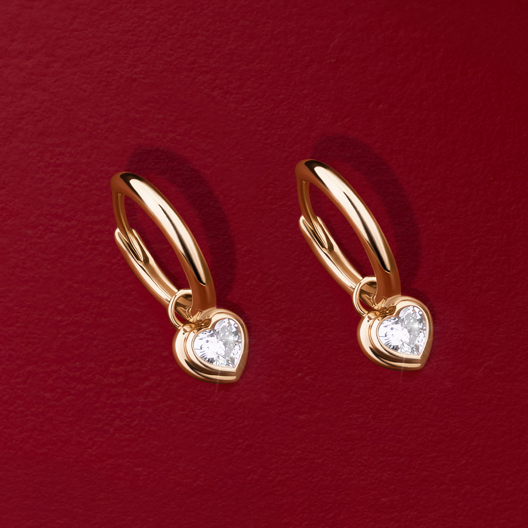Flat lay view of the Wallace Bishop 0.30 TDW Heart Lab-Grown Diamond Double Bezel Drop Earrings in 9ct Yellow Gold, reference LGHUGH30, measuring 18.10mm in length, laid flat. Each earring features a single heart-shaped lab-grown diamond in a double bezel setting.