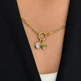 On-body view of a neck wearing two Wallace Bishop Double Bezel Pendants in 9ct Yellow Gold: the 0.30 TDW Pear-Cut Lab-Grown Diamond Double Bezel Pendant, reference LGNDBP30, and the Round Peridot Double Bezel Pendant, reference 93PDRDPE1Y, with the pear-cut diamond and the round green peridot each set in a polished gold double bezel.
