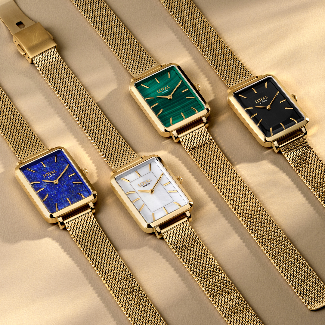 Four Loyal Academy Quartz Women’s 24.50mm watches, exclusive to Wallace Bishop, laid side by side, each with a Gold PVD rectangular case and a mesh bracelet. From left to right they are the Mother-of-Pearl dial, reference 20D4126, the Lapis Lazuli dial, reference 20D4128, the Black Onyx dial, reference 20D4127, and the Malachite dial, reference 20D4125.