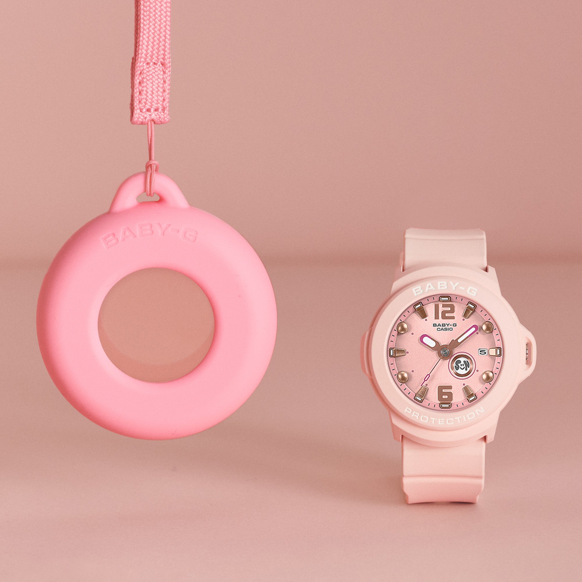 Casio Baby-G BGA15K-4A front view showcasing the soft pastel pink matte bezel and band with shimmering metal dial, pop-inspired rotating day display, and clean three-hand analogue face — the convertible Baby-G+PLUS watch that doubles as a bag charm.
