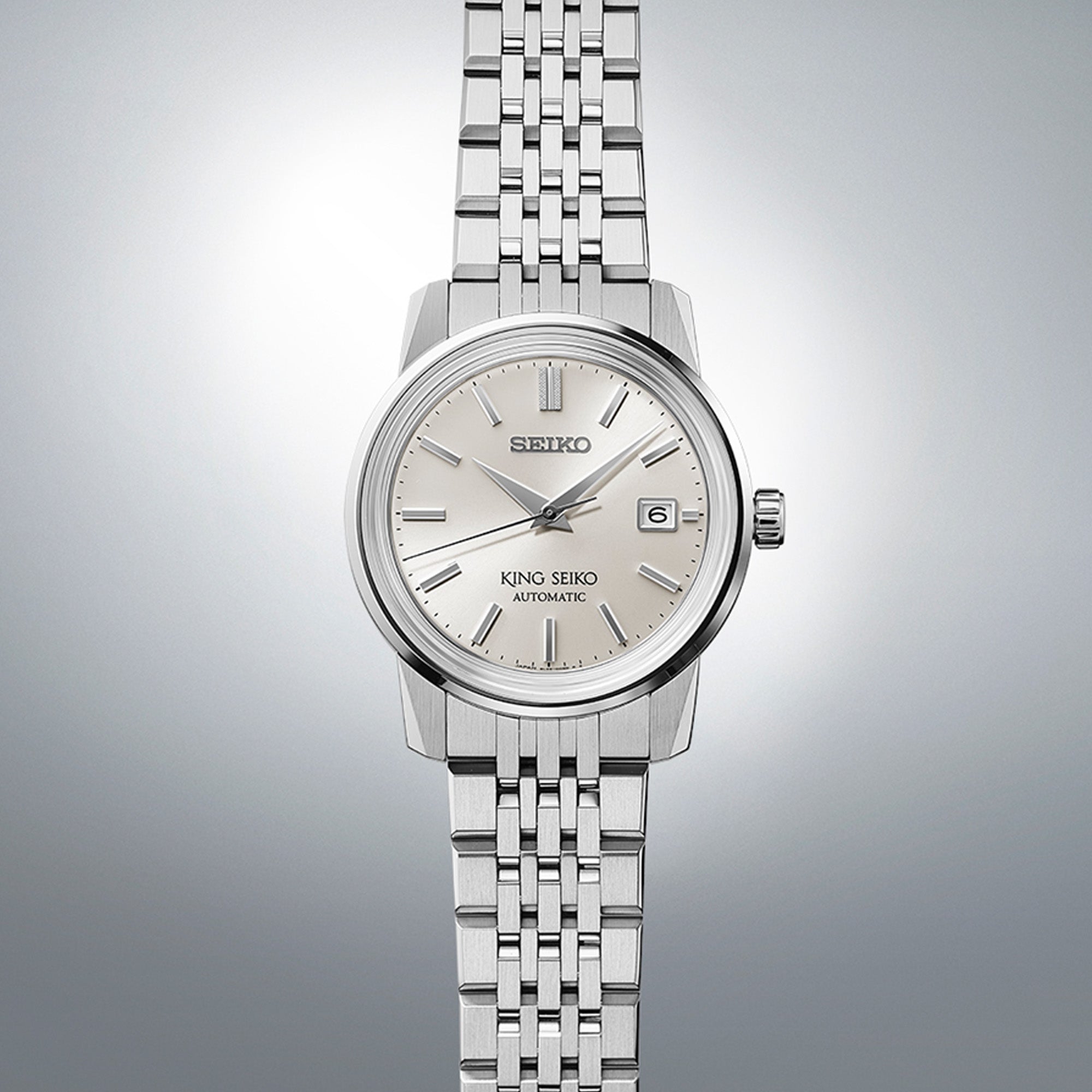 Close-up of King Seiko SJE089J silver dial showing applied indices, three hands, and date complication