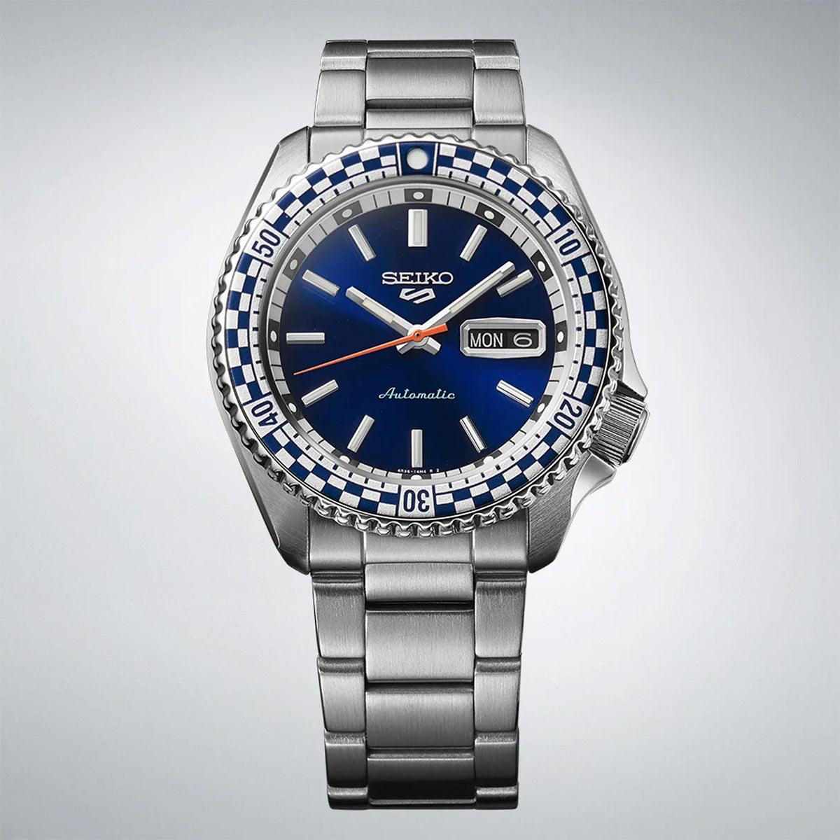 The Seiko 5 Sports Automatic Men’s 42.50mm Watch SRPK65K shows the dial’s baton markers, vintage-style hands and day-date window. The checkered bezel insert sits around the dial.