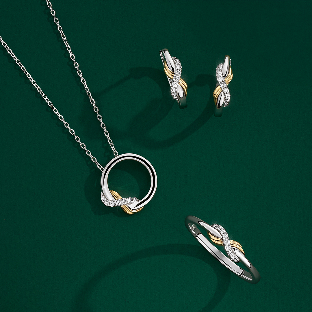 Front-on view of three Wallace Bishop Round Diamond Infinity pieces in Sterling Silver & 9ct Yellow Gold: the 0.04 TDW Pendant, reference 37NKSINFTY, on a 500mm (approximately 19.7 inch) chain, the 0.11 TDW Huggies, reference 37ERINFTY, and the 0.05 TDW Ring, reference 37RGINFTYO. Each piece features an infinity design with round diamonds set into the silver section and a polished yellow gold section.
