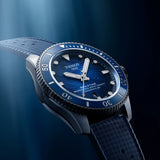 Tissot Seastar 2000 44mm T120.907.17.041.00 with a blue sunburst dial, silver-tone case, and textured blue strap, shown at an angle against a dark blue background with soft light rays.