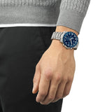 Tissot Supersport Chrono 42mm T125.417.11.041.00 worn on wrist – blue chronograph dial, stainless steel case with aluminium bezel, grey steel bracelet, bold 42mm quartz chronograph shown on wrist