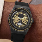 The Timex x Harry Potter Time Turner Quartz 36mm Watch TW2Y76000 pairs its 36mm stainless steel case with a black leather strap on the wrist. The gold hourglass dial stands out against the black strap.
