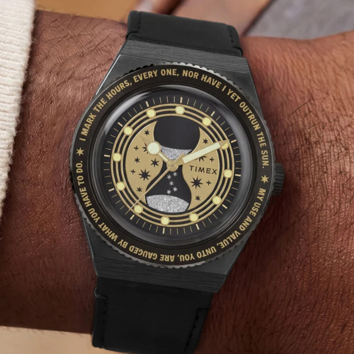 The Timex x Harry Potter Time Turner Quartz 36mm Watch TW2Y76000 pairs its 36mm stainless steel case with a black leather strap on the wrist. The gold hourglass dial stands out against the black strap.