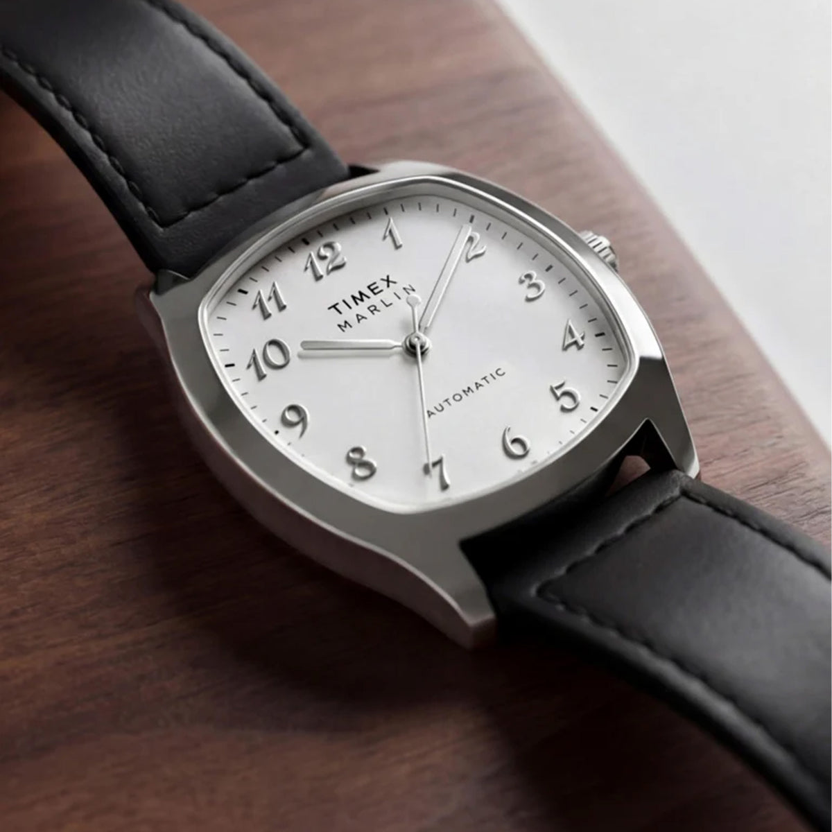 The Timex Marlin Chatham Automatic 36mm Watch TW2Y84300 is shown. The white dial and black leather strap bring a mid-century look to relaxed everyday outfits.