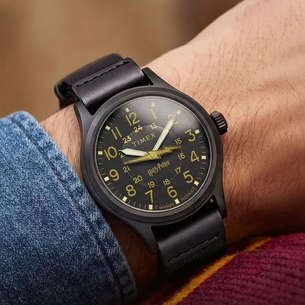 The Timex x Harry Potter Bolt Expedition Scout Quartz 40mm Watch TW6A05700 pairs its black 40mm case with a black fabric strap with leather tabs on the wrist. The all-black look suits casual outfits.