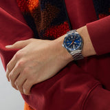 TAG Heuer Formula 1 Date WAZ1010.BA0842 shown worn on the wrist, illustrating the case proportions and steel bracelet fit. The blue dial stands out against the sleeve in frame.