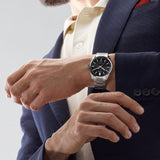 TAG Heuer Carrera Date WBN2110.BA0639 shown worn on the wrist, illustrating the case proportions and steel bracelet fit. The black dial stands out against the sleeve in frame.
