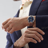 TAG Heuer Carrera Date WBN2112.BA0639 shown worn on the wrist, illustrating the case proportions and steel bracelet fit. The blue dial stands out against the sleeve in frame.