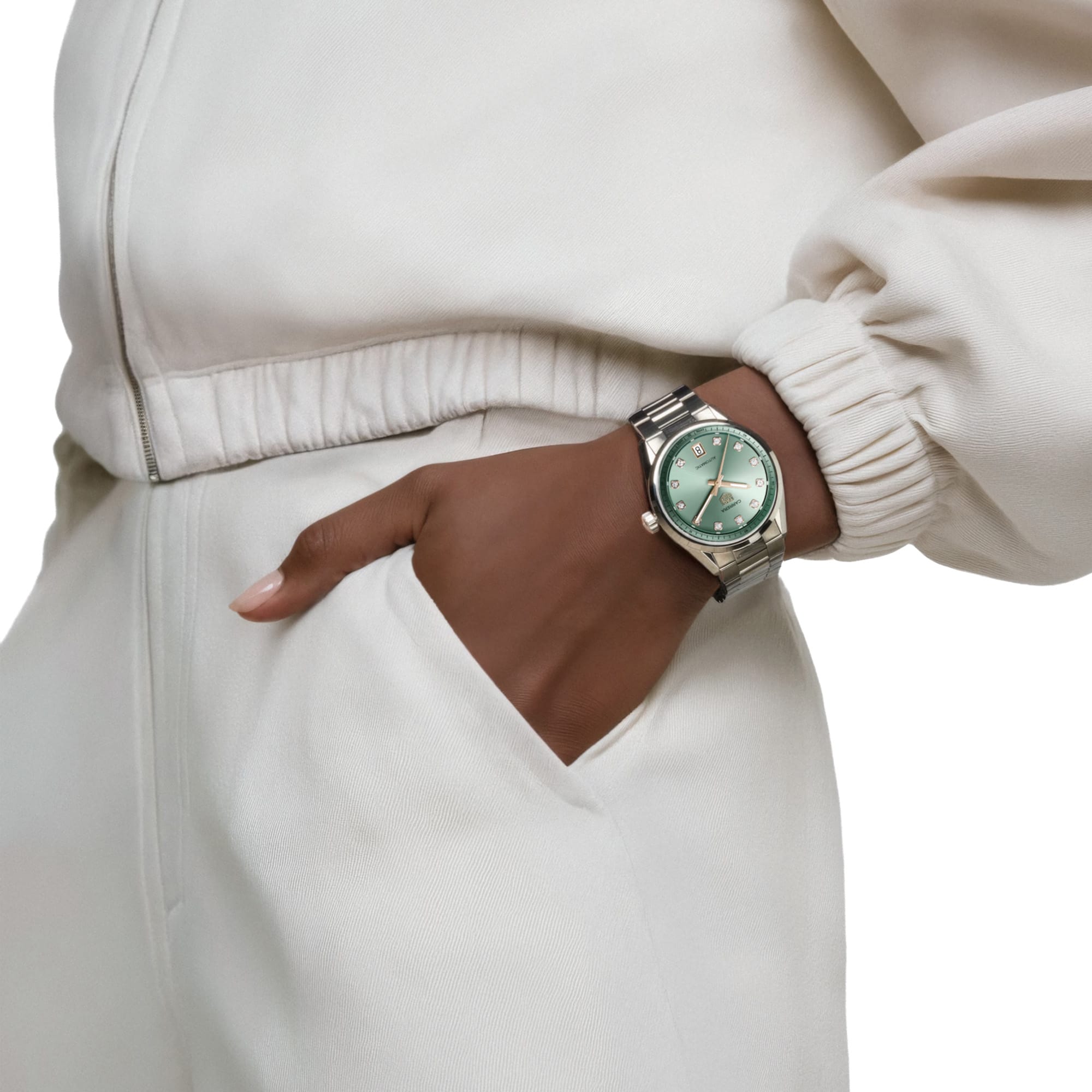 TAG Heuer Carrera Date WBN2317.BA0001 shown worn on the wrist, illustrating the case proportions and steel bracelet fit. The green dial stands out against the sleeve in frame.