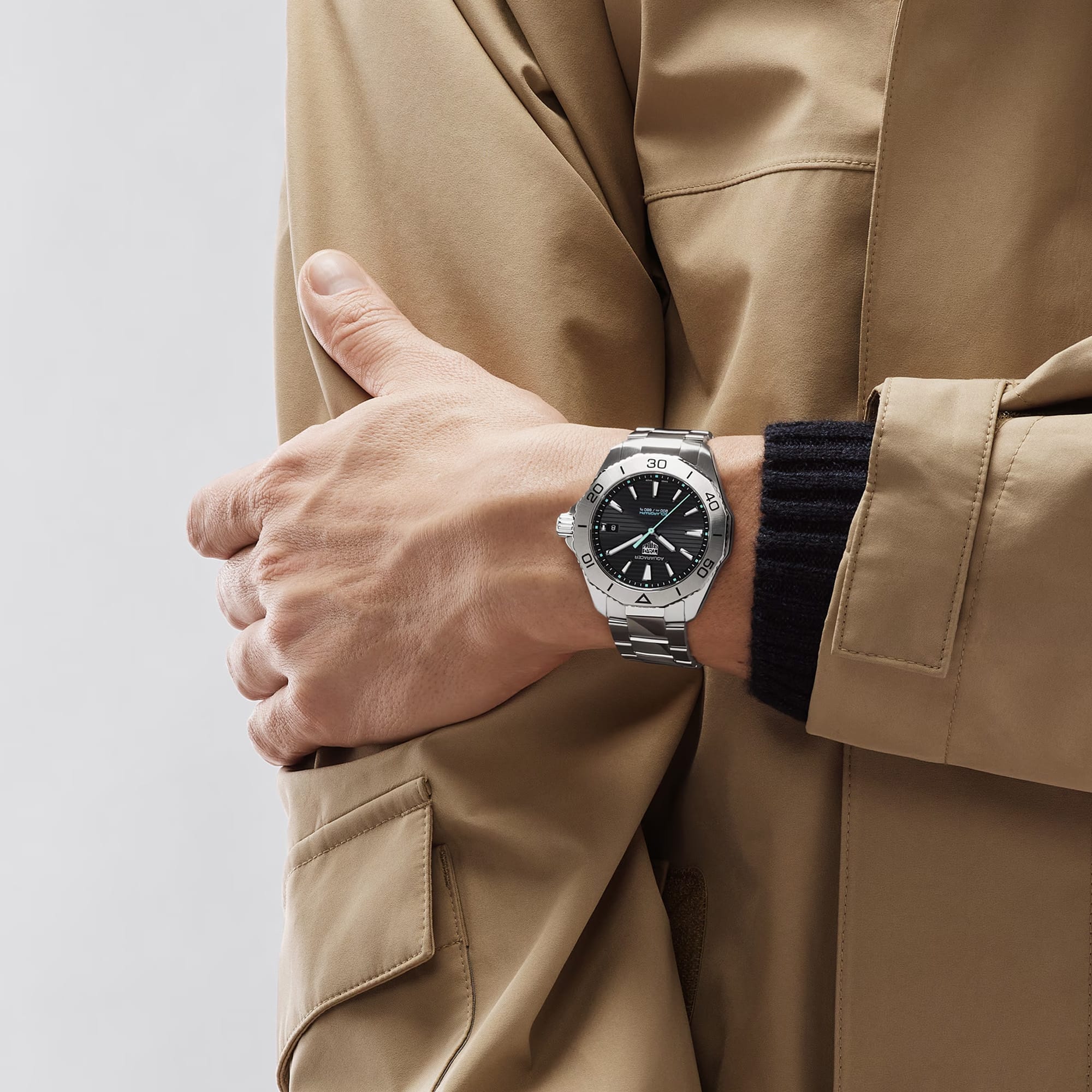 TAG Heuer Aquaracer Professional 200 Solargraph WBP1114.BA0000 shown worn on the wrist, illustrating the case proportions and steel bracelet fit. The black dial stands out against the sleeve in frame.