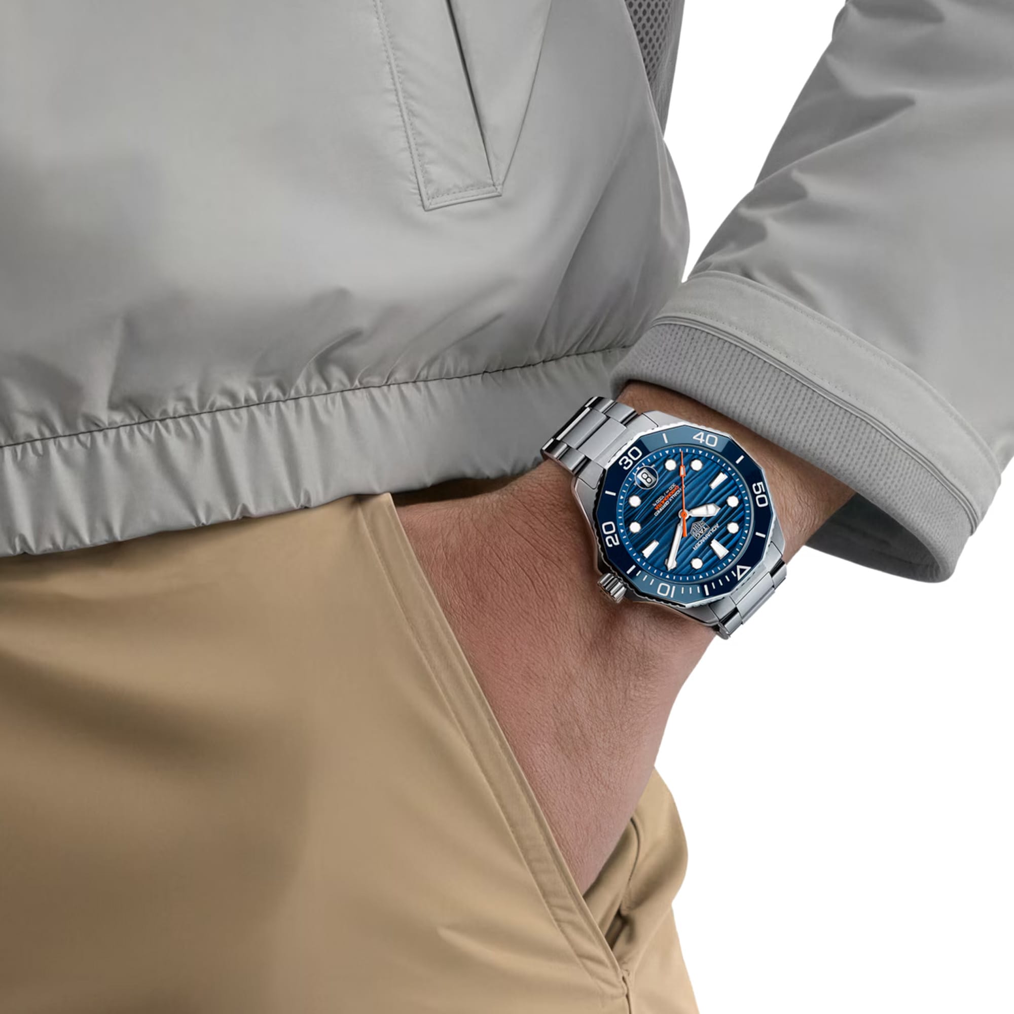 TAG Heuer Aquaracer Professional 300 Date WBP5111.BA0013 shown worn on the wrist, illustrating the case proportions and steel bracelet fit. The blue dial stands out against the tan jacket sleeve in frame.