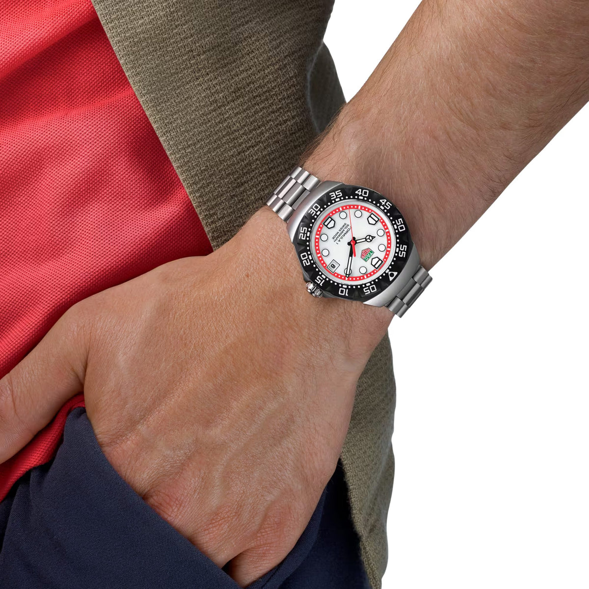 TAG Heuer Formula 1 Solargraph WBY1111.BA0042 shown worn on the wrist, illustrating the case proportions and steel bracelet fit. The white dial stands out against the dark jacket sleeve in frame.