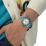 TAG Heuer Formula 1 Solargraph WBY111E.BA0042 shown worn on the wrist, illustrating the case proportions and steel bracelet fit. The white dial and green bezel stand out against the colourful sleeve in frame.