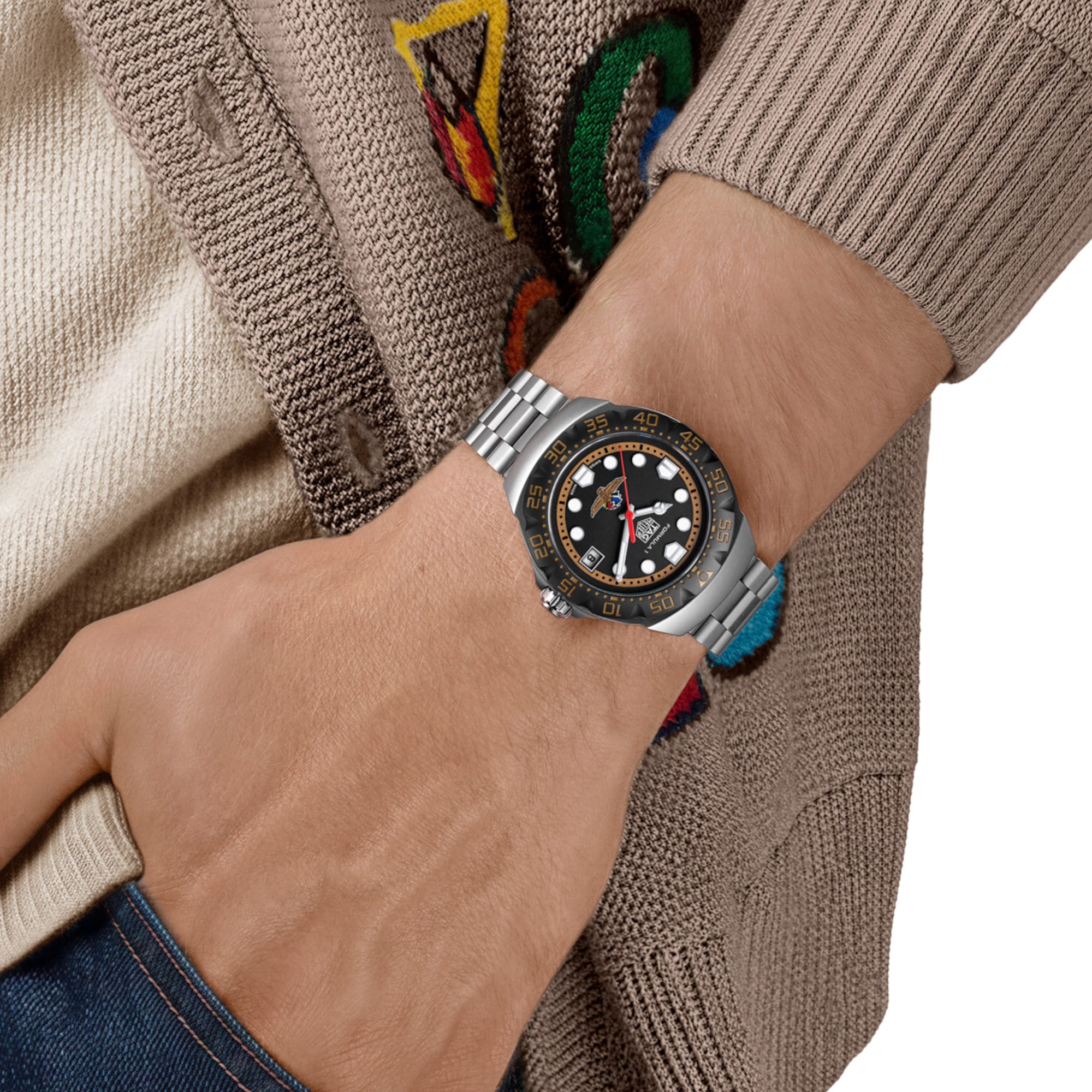 TAG Heuer Formula 1 Solargraph x Indy 500 WBY111G.BA0042 shown worn on the wrist, illustrating the case proportions and steel bracelet fit. The black dial stands out against the neutral tone of the sleeve in frame.