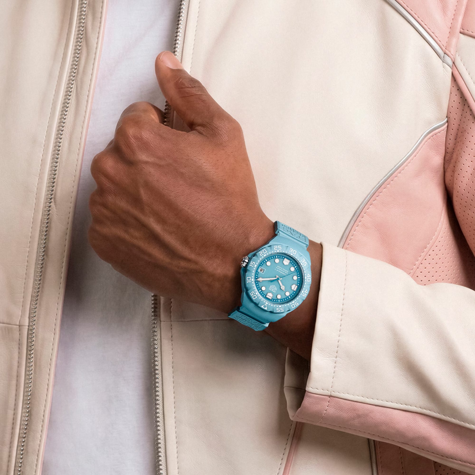 TAG Heuer Formula 1 Solargraph WBY1163.FT8113 shown worn on the wrist, illustrating the case proportions and blue rubber strap fit. The pastel blue dial stands out against the light-coloured sleeve in frame.