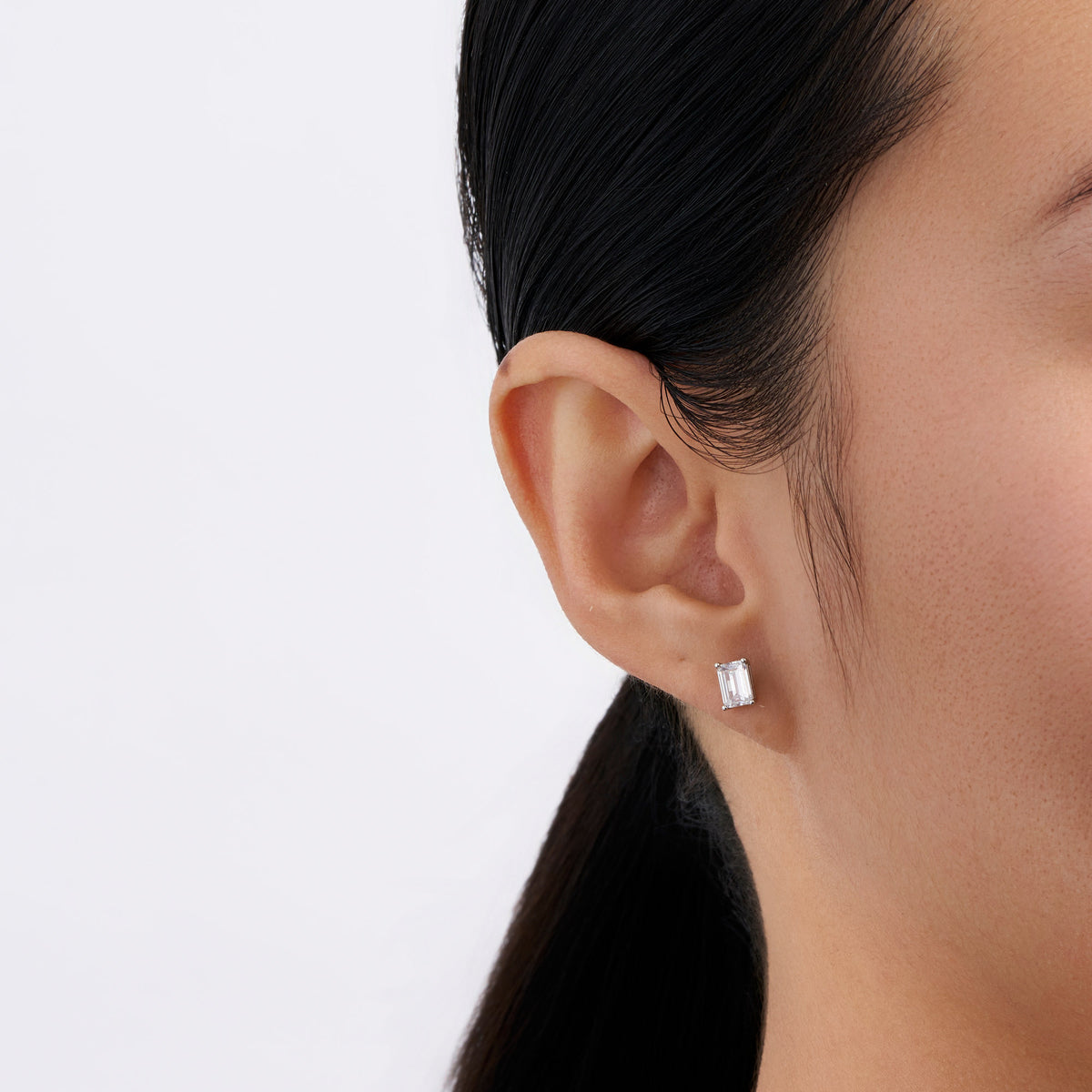 On-body view of a model wearing the Wallace Bishop Freshwater Pearl & Cubic Zirconia Drop Earrings in Sterling Silver, with emerald cut cubic zirconia.