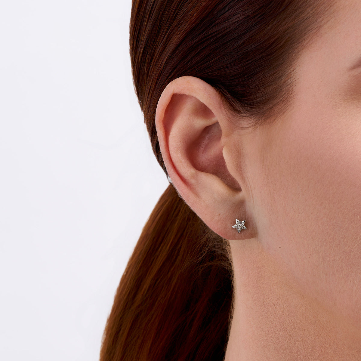 On-body view of a model wearing the Wallace Bishop 0.15 TDW Round Diamond Star Stud Earrings in Sterling Silver, with a pavé set diamond star in each earlobe.